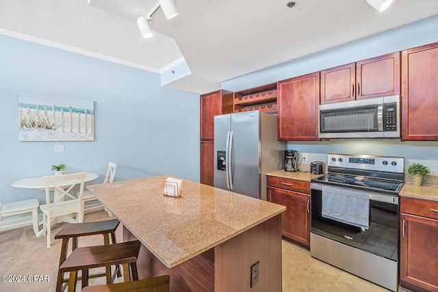 kitchen with light stone counters, stainless steel appliances, a kitchen breakfast bar, a center island, and open shelves