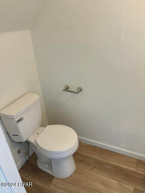 bathroom featuring wood-type flooring and toilet