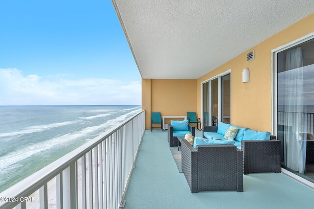 balcony with a water view and an outdoor hangout area