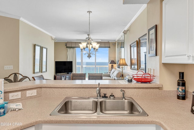 kitchen with crown molding, a chandelier, sink, and hanging light fixtures