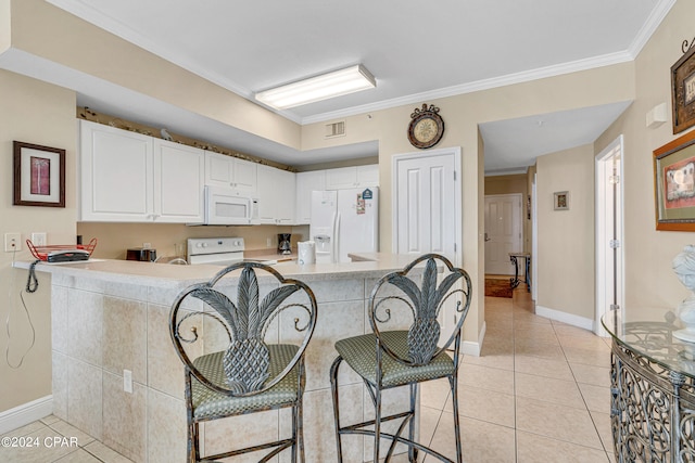 kitchen featuring white appliances, crown molding, a breakfast bar, kitchen peninsula, and white cabinetry