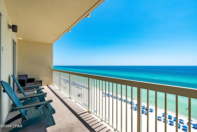 balcony featuring a view of the beach and a water view