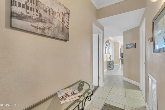 corridor featuring crown molding and light tile patterned floors