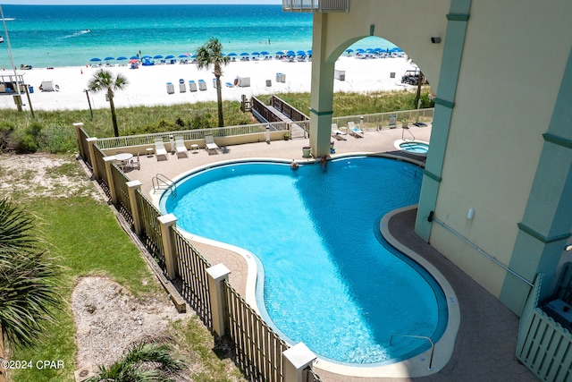 view of pool with a patio and a water view