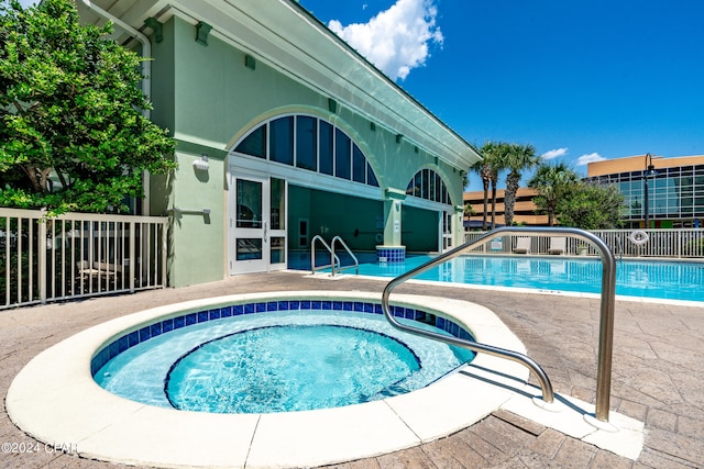 view of swimming pool with a hot tub and a patio