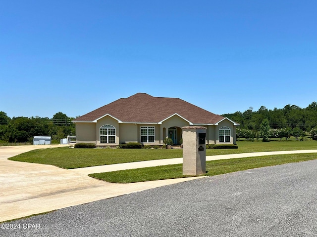 ranch-style home with a garage and a front lawn