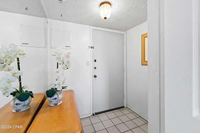 entrance foyer with a textured ceiling and light tile patterned flooring