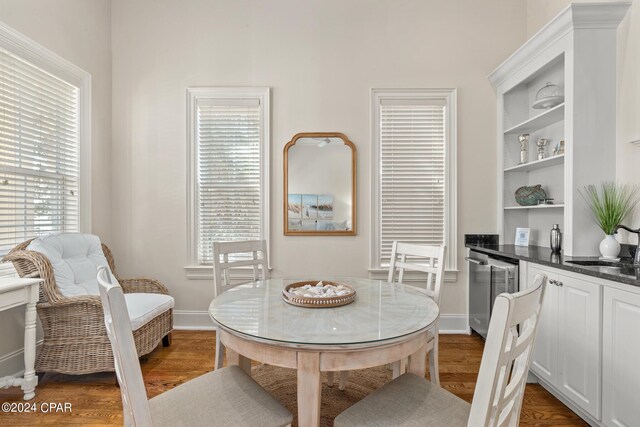 dining space featuring sink, a healthy amount of sunlight, and dark hardwood / wood-style flooring