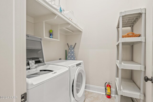 laundry room with light tile patterned floors and washing machine and dryer