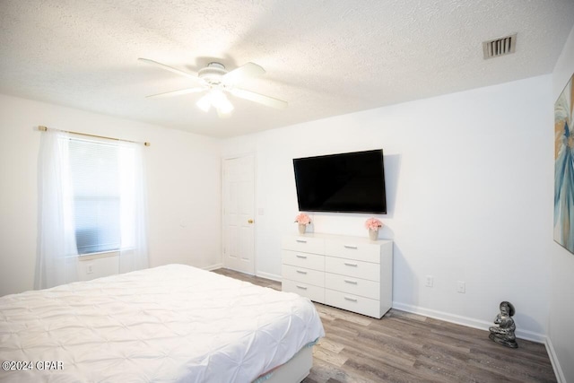 bedroom featuring a textured ceiling, light hardwood / wood-style flooring, and ceiling fan