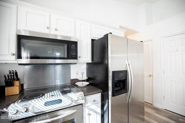 kitchen with appliances with stainless steel finishes, white cabinetry, and wood-type flooring