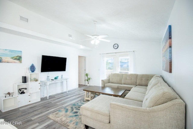 living room with lofted ceiling, ceiling fan, and light wood-type flooring