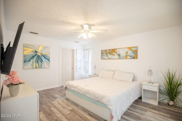 bedroom featuring a textured ceiling, ceiling fan, and hardwood / wood-style flooring