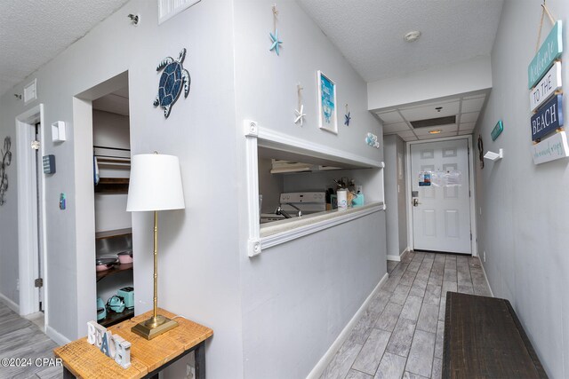 entryway with a textured ceiling and light hardwood / wood-style floors