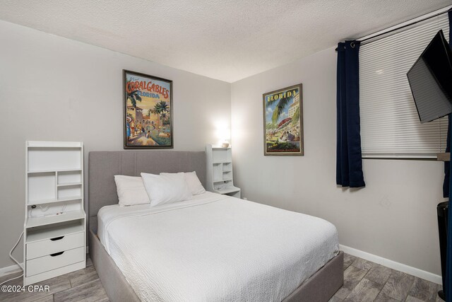 bedroom with a textured ceiling and hardwood / wood-style floors