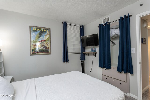 bedroom featuring a textured ceiling and hardwood / wood-style flooring