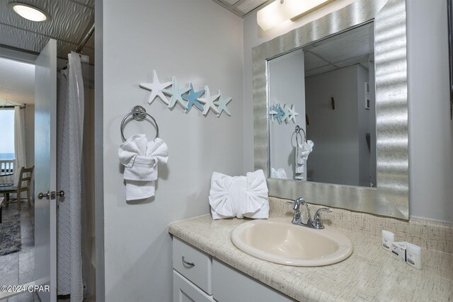 bathroom with curtained shower and vanity