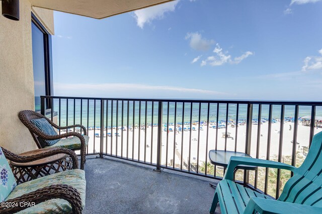 balcony featuring a view of the beach and a water view