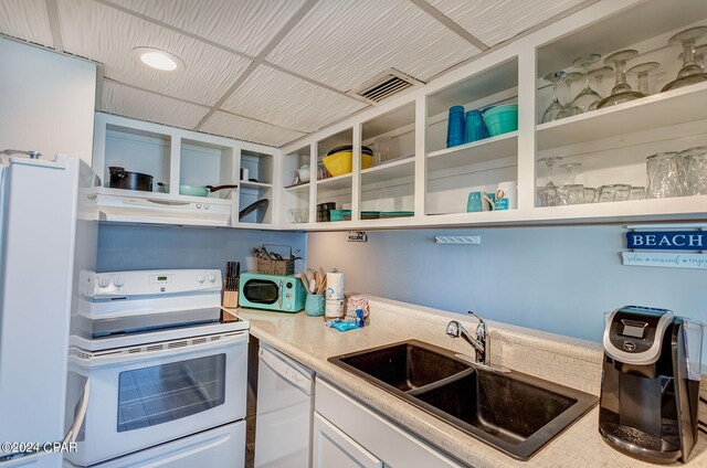 kitchen with exhaust hood, sink, white appliances, and white cabinetry