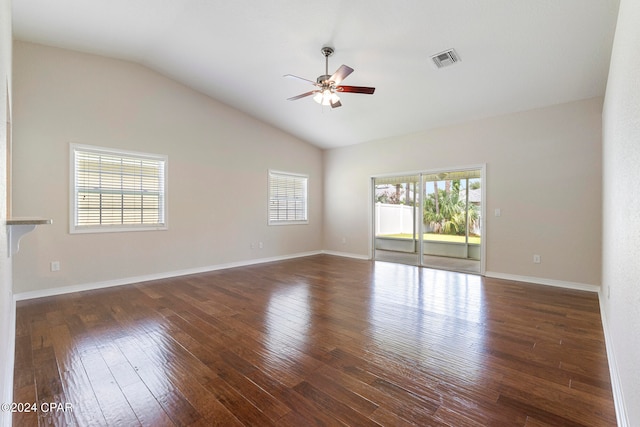 empty room featuring a wealth of natural light, lofted ceiling, ceiling fan, and dark hardwood / wood-style floors