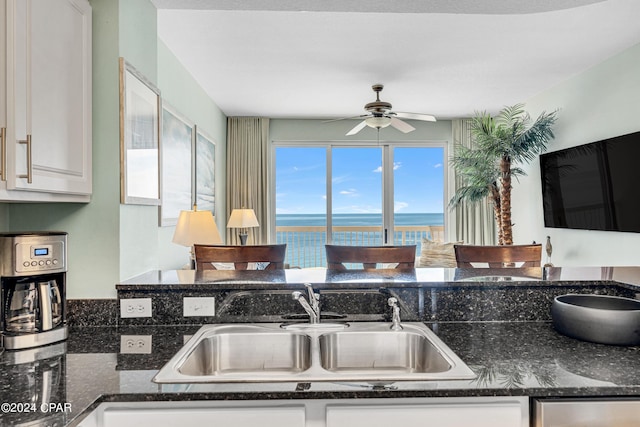 kitchen featuring a wealth of natural light, white cabinets, and sink