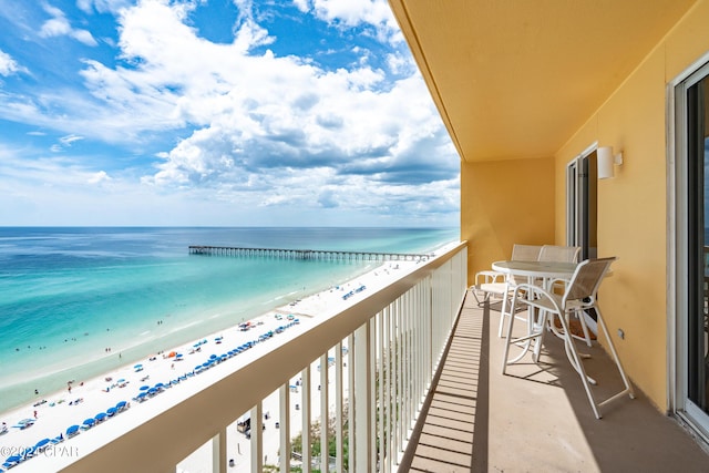 balcony featuring a water view and a view of the beach