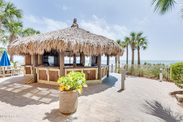 view of pool with a water view, a patio area, and a view of the beach