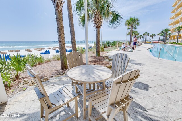 wooden deck featuring a water view and a view of the beach