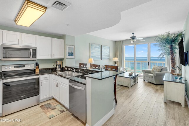 kitchen featuring sink, white cabinets, appliances with stainless steel finishes, and kitchen peninsula