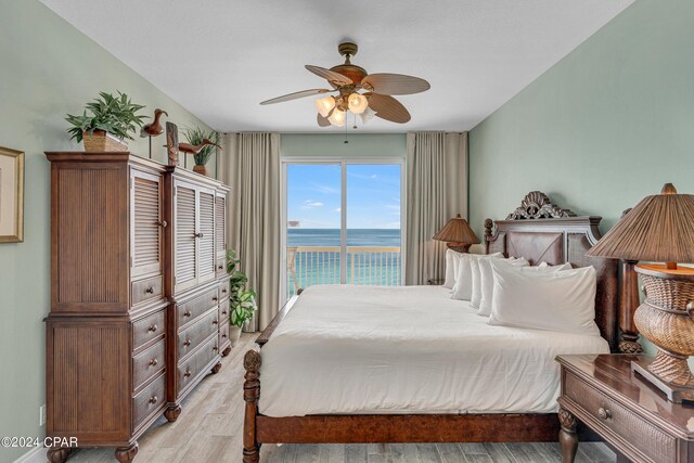 bedroom featuring ceiling fan, access to exterior, a water view, and light wood-type flooring