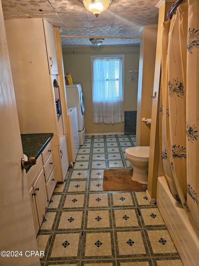 full bathroom with tile patterned flooring, toilet, shower / bath combo with shower curtain, vanity, and washing machine and dryer