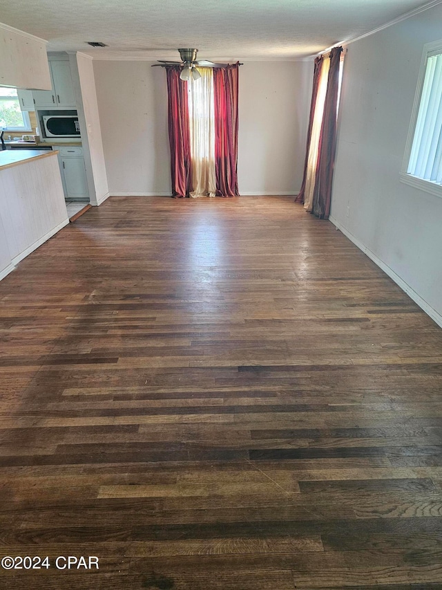 unfurnished living room with dark hardwood / wood-style floors and ornamental molding