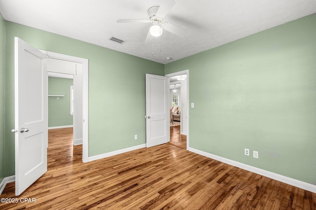 unfurnished bedroom featuring wood-type flooring, ceiling fan, and a closet