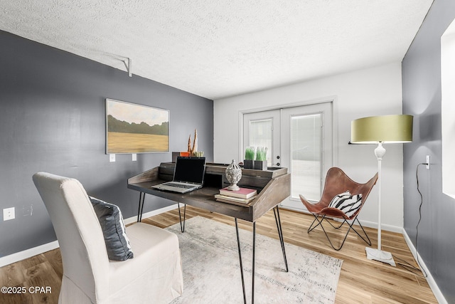 home office with french doors, hardwood / wood-style floors, and a textured ceiling