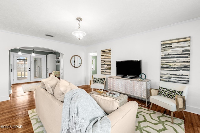 living room with hardwood / wood-style flooring, crown molding, and a textured ceiling