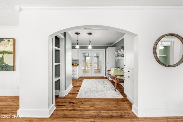 foyer with hardwood / wood-style floors, ornamental molding, and french doors