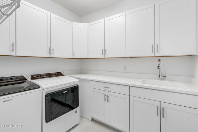 laundry room with washer and clothes dryer, sink, and cabinets