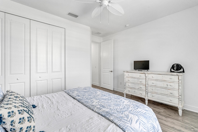 bedroom featuring hardwood / wood-style flooring, ceiling fan, and a closet