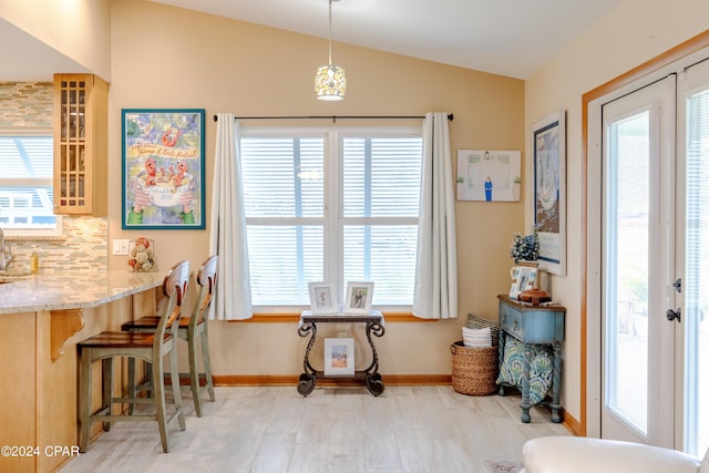 dining area with vaulted ceiling, french doors, light wood finished floors, and plenty of natural light