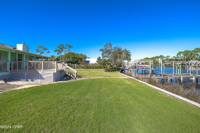 view of yard featuring a water view, a boat dock, and boat lift