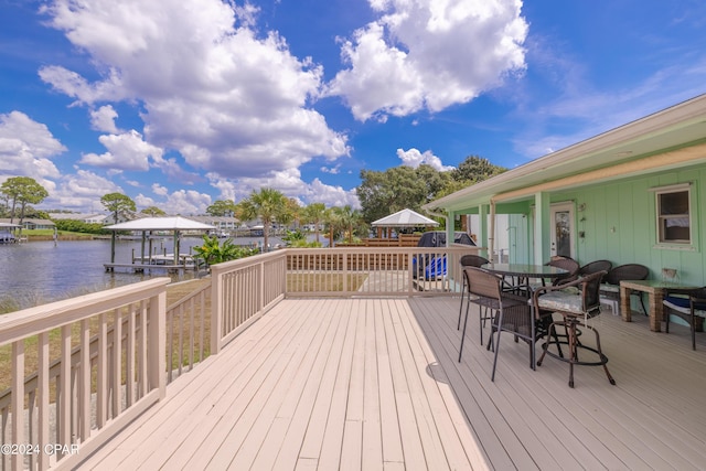 wooden deck featuring a water view and outdoor dining space