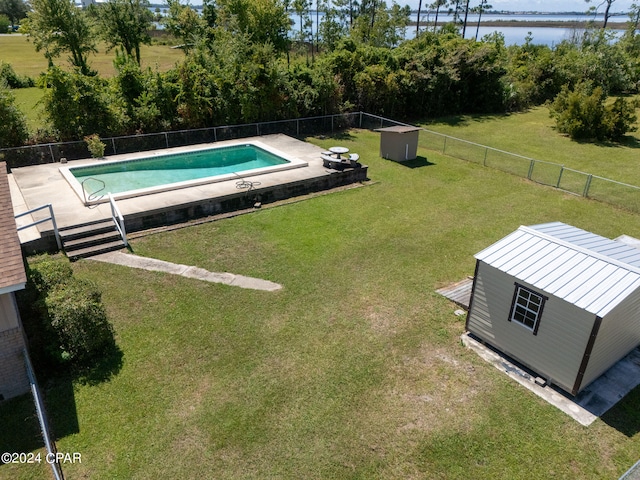 view of pool featuring a lawn and a shed