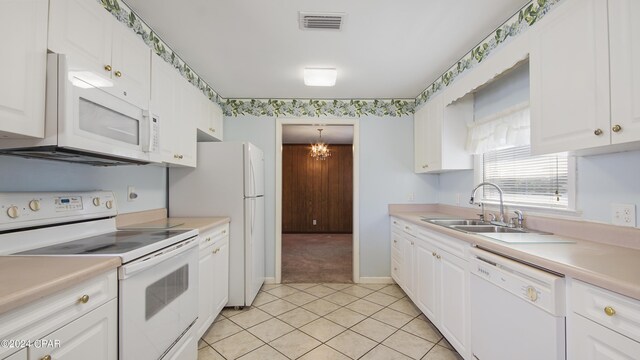 kitchen with white cabinets, white appliances, an inviting chandelier, and sink