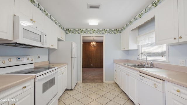 kitchen featuring light countertops, visible vents, white cabinetry, a sink, and white appliances