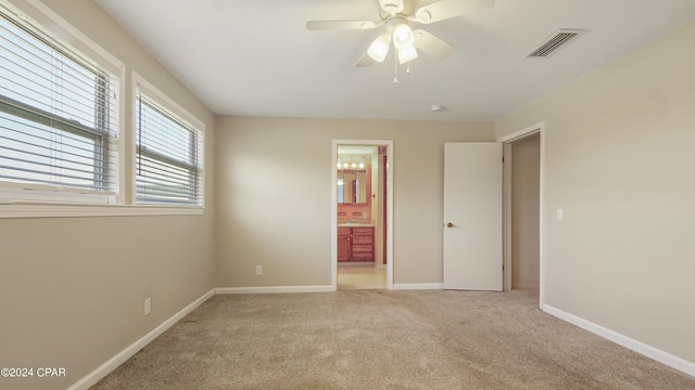 unfurnished bedroom with ceiling fan, carpet floors, visible vents, baseboards, and ensuite bath