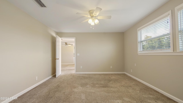 unfurnished room with ceiling fan, carpet floors, visible vents, and baseboards