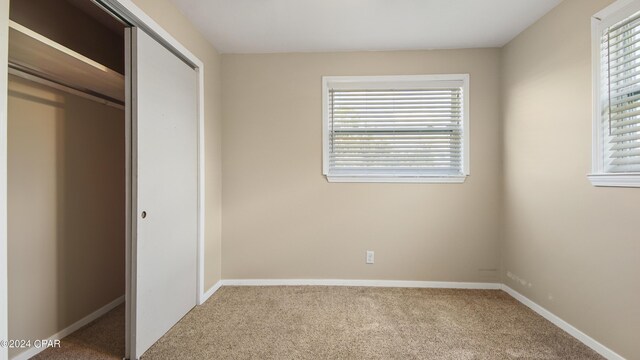 unfurnished bedroom with a closet and carpet flooring