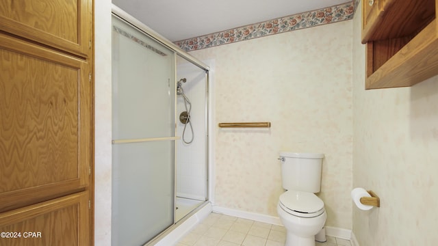 bathroom with a stall shower, wallpapered walls, baseboards, toilet, and tile patterned floors