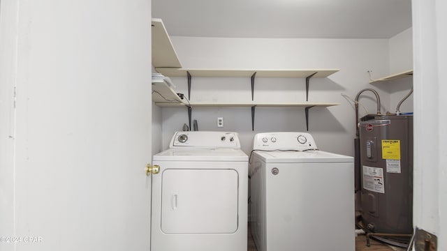 washroom featuring laundry area, electric water heater, and separate washer and dryer