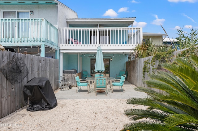 back of property with a balcony and a patio area